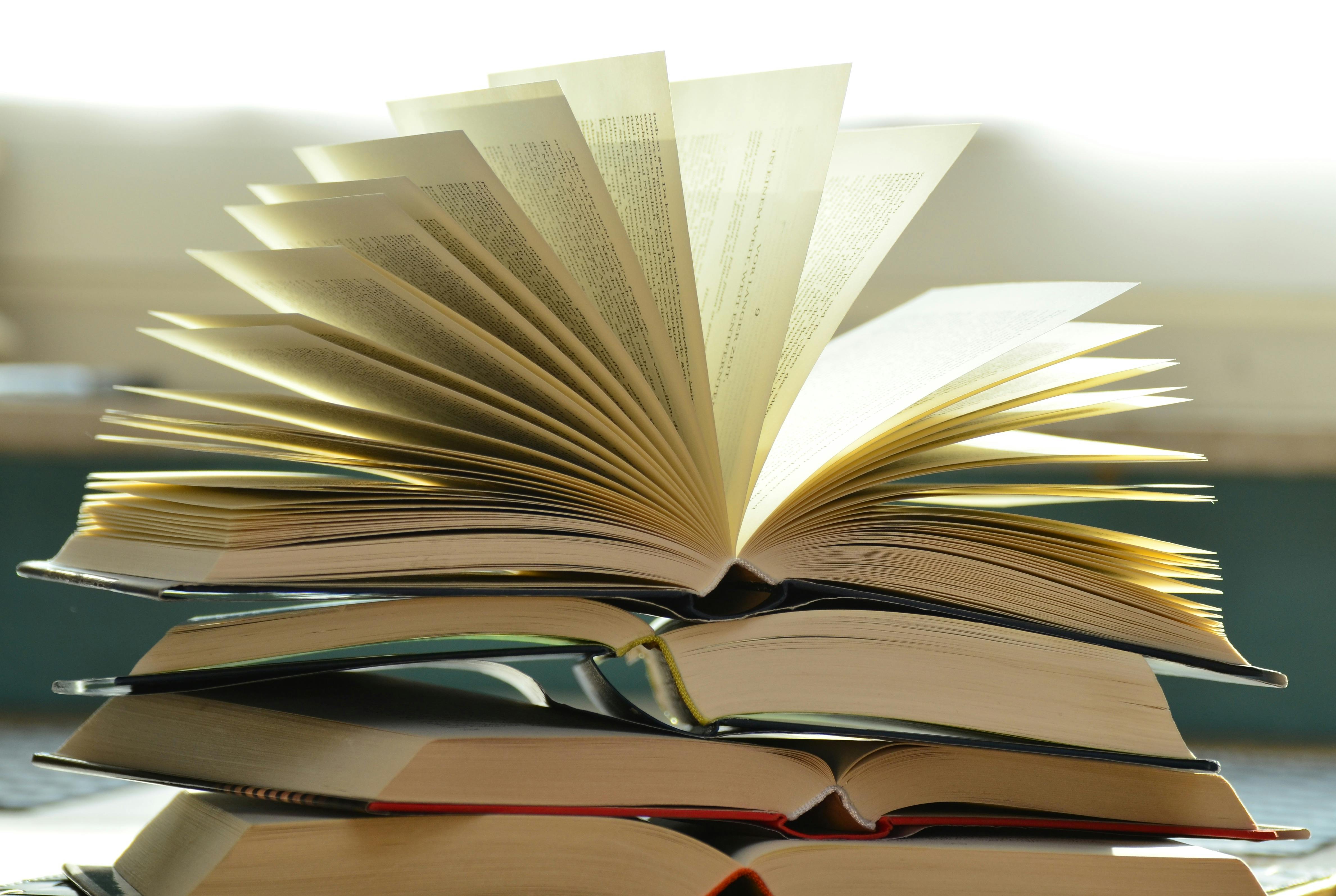 Pile de livres ouverts, symbolisant la surcharge d'informations en développement personnel