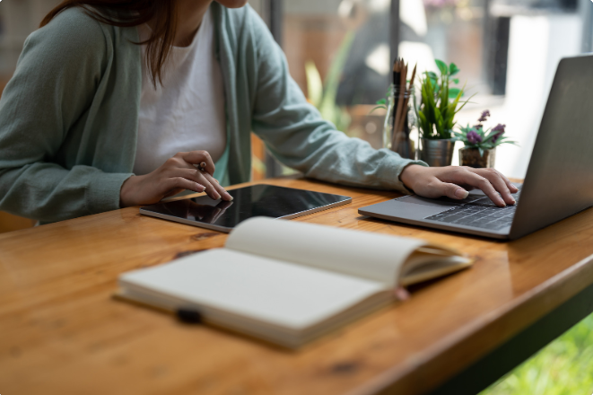 Photo illustrant une consultante en organisation, travaillant à un bureau avec un ordinateur portable et un carnet, symbolisant la réflexion et la planification.