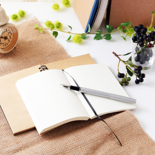 Carnet ouvert avec stylo dans une ambiance lumineuse, évoquant la création libre et intuitive