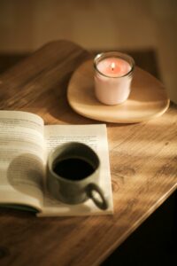 Carnet papier posé près d’une bougie et d’une tasse, invitant à une pause d’écriture en douceur