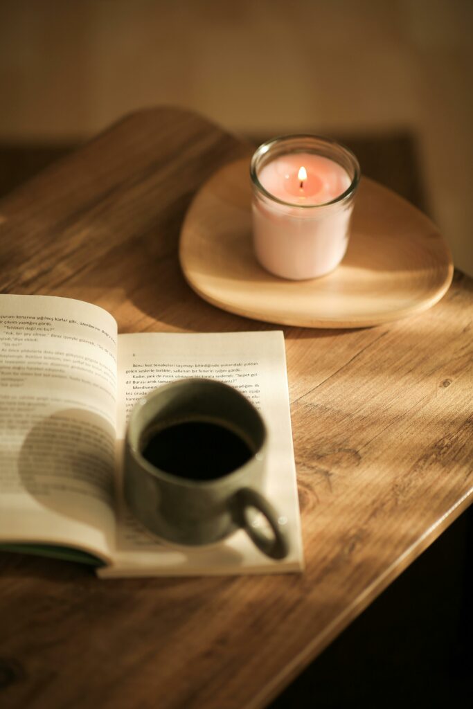 Carnet papier posé près d’une bougie et d’une tasse, invitant à une pause d’écriture en douceur