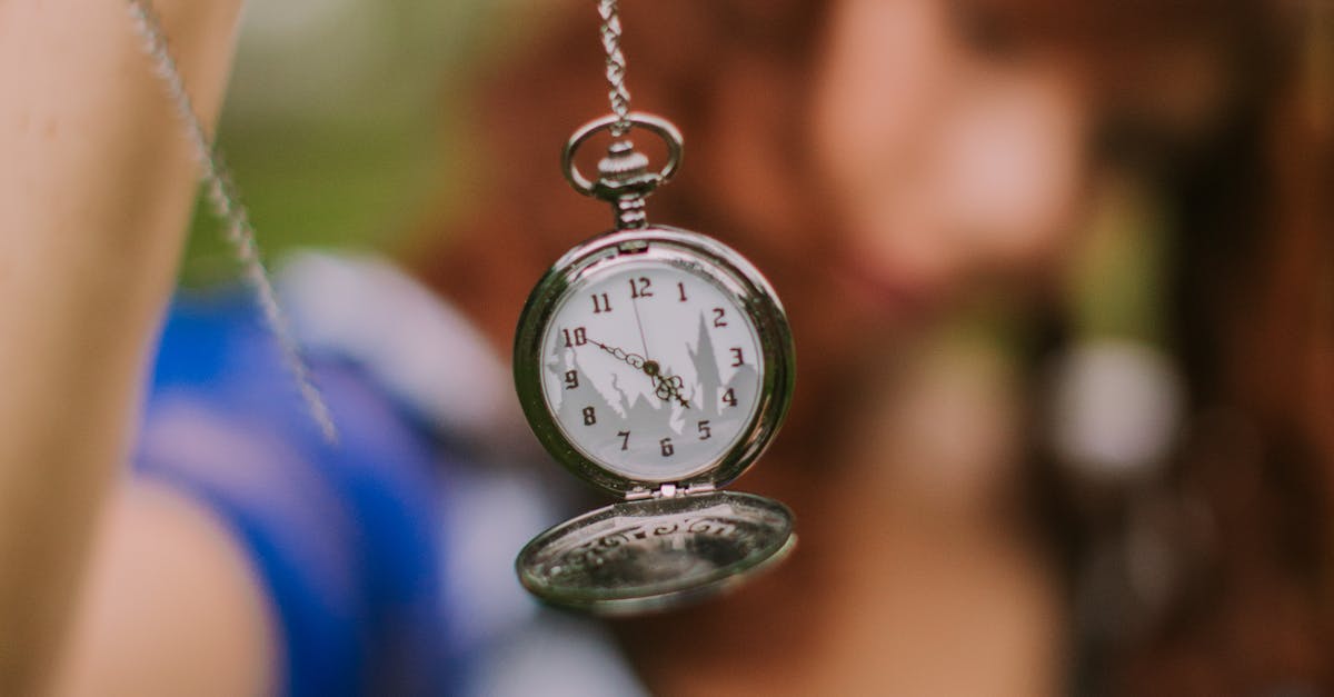 Montre à gousset floue tenue en main, symbolisant le temps qui passe